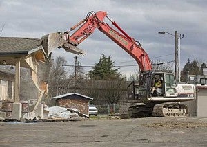 A bulldozer knocking down a building