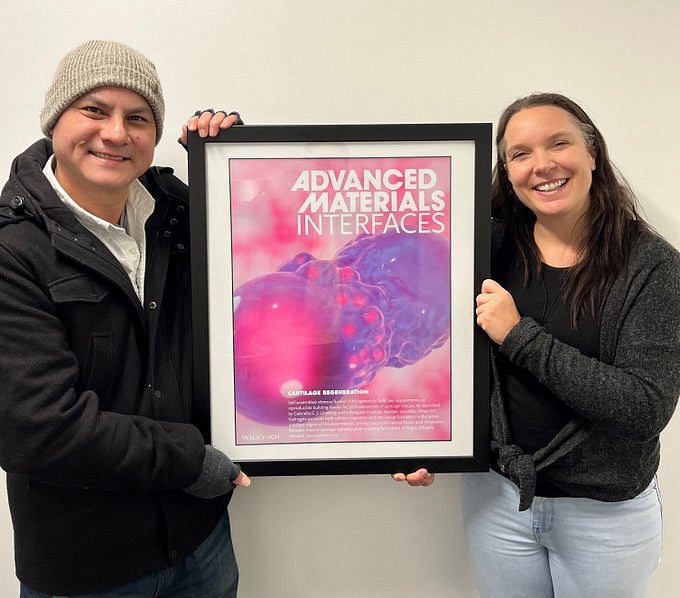 Knight Campus recruiting manager Chakris Kussalanant (left) and assistant professor Gabriella Lindberg (right) post with illustration between them