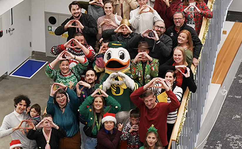 A group of people posing with Duck mascot