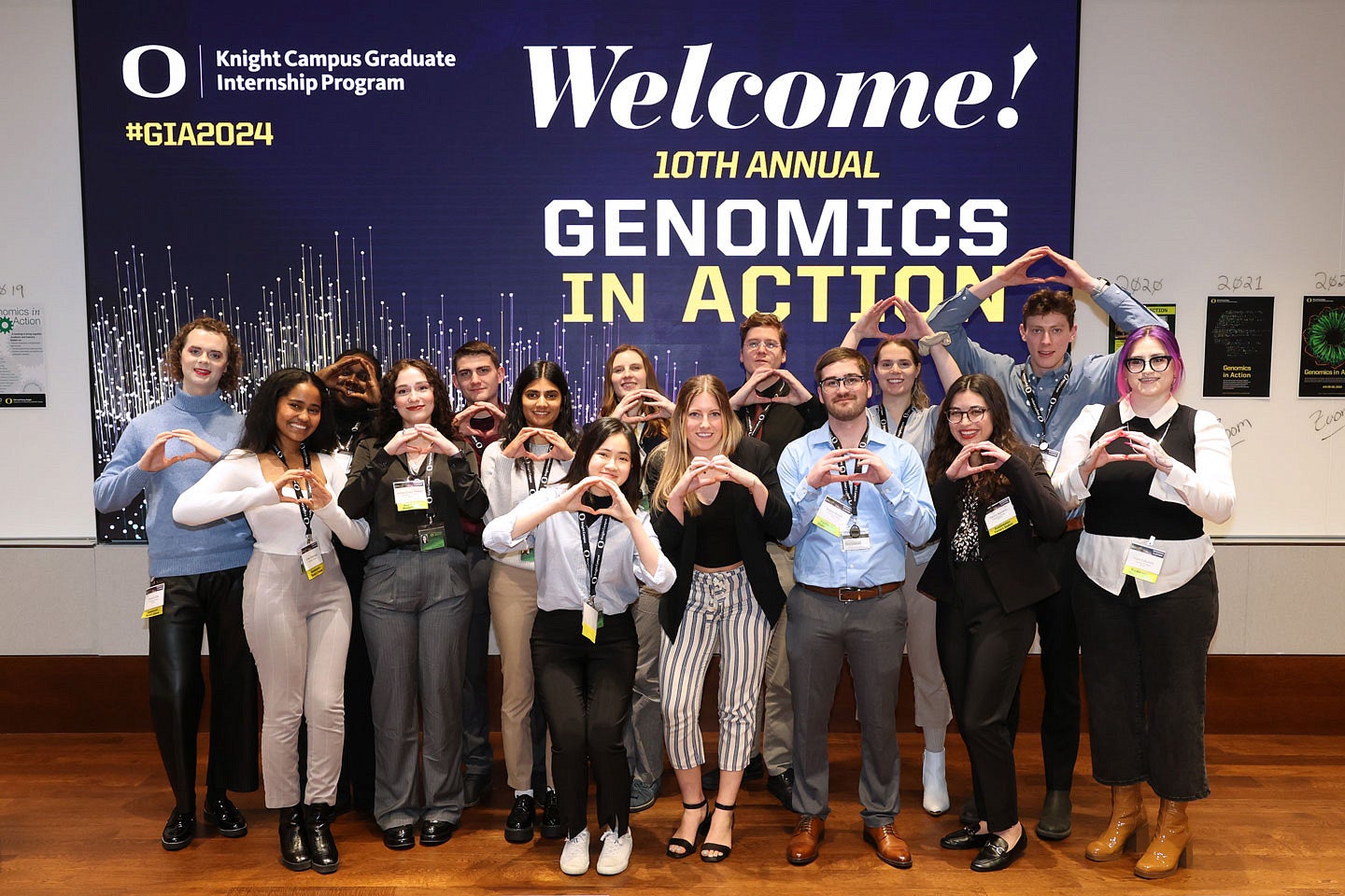 Group of students throwing the O in front of Genomics in Action slide
