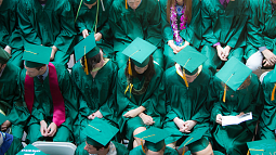 Graduates in green caps and gowns as seen from above