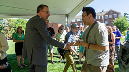 UO President Scholz (right) shakes hands with an attendee at a recent ice cream social